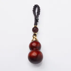 Polished sandalwood gourd keychain with hand-woven rope and intricate carving detail