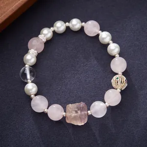 Macro detail of natural rose quartz bracelet with fluorite and gold hollow bead