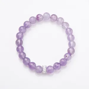 Natural amethyst beaded bracelet with sparkling zircon cylinder charm on a white background