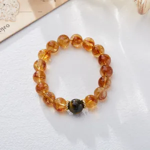 Brazilian citrine bracelet featuring translucent orange beads and blue cat-eye stone accent