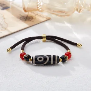 Macro detail of hand-woven bracelet with Nine-Eyed Agate Dzi bead and Six-Syllable beads