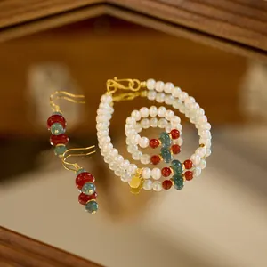 Detailed set of pearl and jade jewelry with lucky gold charms on a mirror
