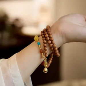 Collier en bois de santal avec pendentif cloche dorée et pierres précieuses colorées