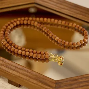 Collier élégant en perles de santal avec pendentif vintage doré et pierres précieuses