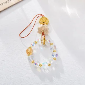 Gros plan de perles de cristal aurora et d'un pendentif lotus sculpté avec des accents dorés