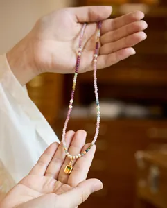 Detalle del collar de turmalina arcoíris y perlas con colgante thangka dorado