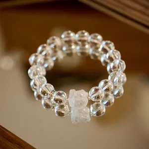 10mm weißes Kristall-Armband mit Rosen-Schnitzerei auf spiegelnder Oberfläche präsentiert