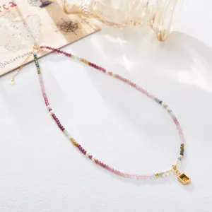 Detalle de collar de turmalina colorida y perlas con colgante de thangka tibetano dorado