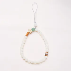 Close-up of beaded phone charm with white bodhi beads and a small wooden flower charm