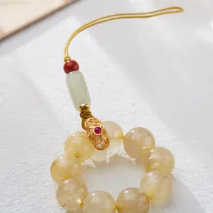 Detailopname van Rutilated Quartz telefoonkoord met jade kralen en gouden filigraanwerk