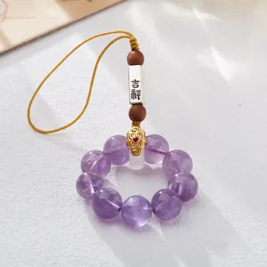 Close-up of purple amethyst beads and silver lucky charm with traditional Chinese knot