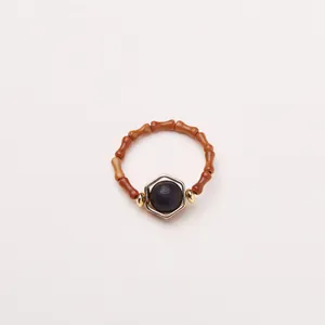 Détail d'une bague en bois de rose avec nœuds de bambou et perle noire sertie d'or