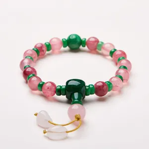 Dettaglio di perle di cristallo rosa e verdi con perla guru verde e ciondoli bianchi