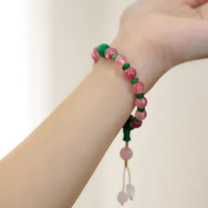 Dettaglio del bracciale con perline di cristallo rosa e distanziali verdi sul polso