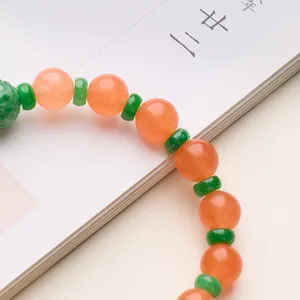 Bracciale tradizionale cinese con perle ambra e distanziali verdi sopra un libro