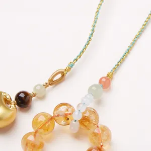 Macro shot of yellow citrine beads and tiger eye stones on a handcrafted woven cord