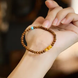 Natural Kuka beads bracelet with turquoise and amber accents on a hand model