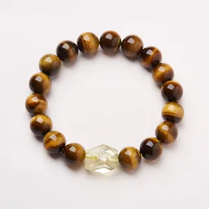 Detailed view of 10mm tiger eye beads and faceted citrine crystal on a beaded bracelet