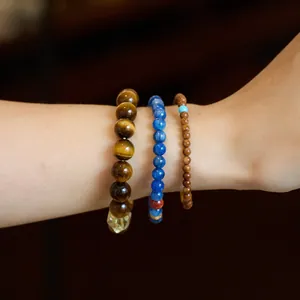 Three Chinese style beaded bracelets featuring tiger eye stone and blue crystal beads