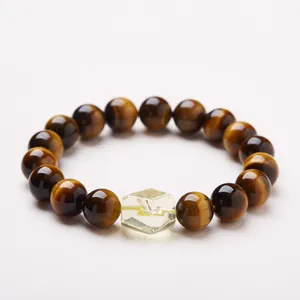 Tiger Eye stone bead bracelet with a yellow crystal cube center on a soft gray background