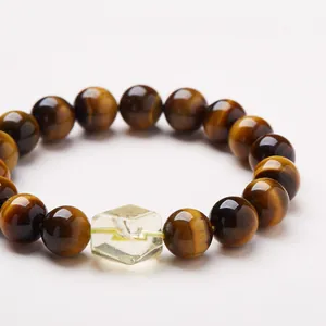 Tiger eye beaded bracelet with a hexagonal yellow crystal centerpiece on white background
