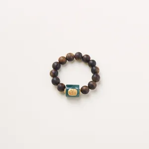 Agarwood beaded bracelet featuring a green jade barrel bead with gold relief carving