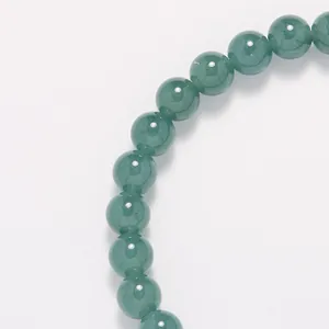 Detalle macro de cuentas de jade azul de 6mm con acabado translúcido natural y suave