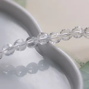 Natürliche 8mm facettierte klare Bergkristallperlenkette auf weißem Porzellanteller