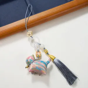 Handcrafted sandalwood lucky cat charm with colorful lacquer patterns and grey silk tassel