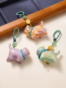 Macro detail of lacquer art lucky cat charm with woven lanyard and golden Fu coin