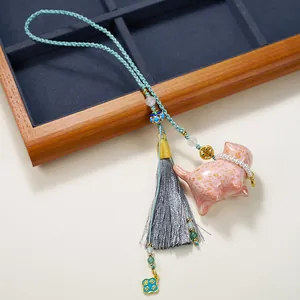 Pink lucky cat lacquer pendant with grey tassel and Good Luck charm on braided rope