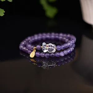Détail macro du bracelet double en améthyste violette avec breloque d'ours en cristal