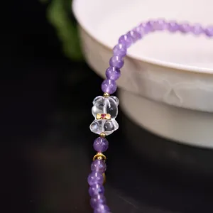 Vue détaillée du bracelet en améthyste violette avec un pendentif en cristal en forme d'ours