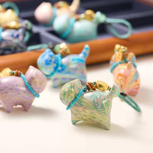 Colorful marble textured lucky cat pendants with vibrant woven lanyards and gold accents