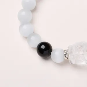 Vue détaillée du bracelet en perles œil de chat blanc avec séparateur et pendentif renard