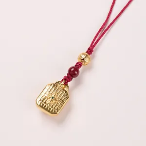 Exquisite gold Zhakiram Thangka pendant with red woven cord and embossed religious patterns