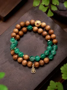 Detail van Afrikaanse jade kralen en sandelhout kralen met een gouden kalebas hanger