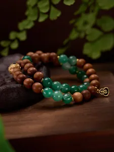 Detail van 8mm Afrikaanse groene jade en sandelhout kralen met gouden kalebas bedeltje