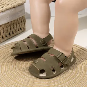 Detail of army green baby closed-toe sandals with metallic buckle and rivet design