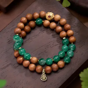 Dubbellaagse armband van Afrikaanse jade en sandelhout met gouden kalebas bedeltje