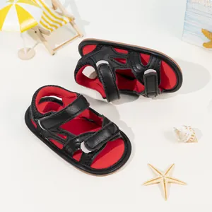 Infant camo sandals with red details and velcro strap on a summer beach scene