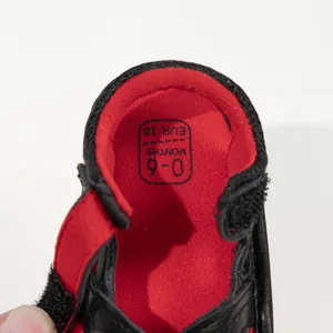 Detail of baby shoe interior with 0-6 months size label and red knitted lining fabric