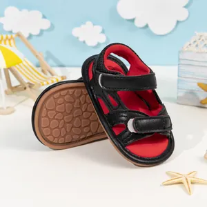 Detail of baby sandal non-slip pebble textured sole and black red hook and loop straps