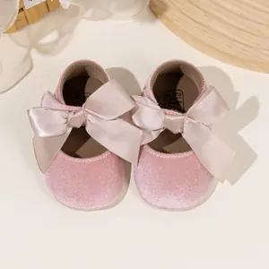 Detailed top view of pink velvet baby shoes with large satin bows and size 16 labels