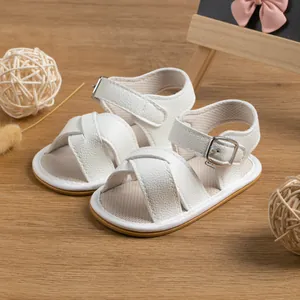 Detail of white leather baby sandals with adjustable metal buckles and soft rubber soles