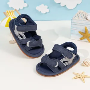 Detail view of navy blue baby sandals with dual velcro straps and soft non-slip soles
