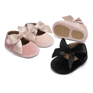 Detailed view of baby princess shoes with satin bows and non-slip soles in pink and black