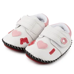 Vue détaillée de chaussures pour bébé avec motifs cœurs et semelle rouge antidérapante