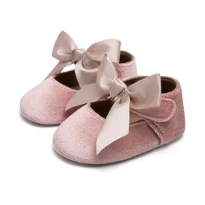 Detailed view of pink velvet baby princess shoes with soft soles and satin ribbon bows