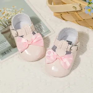 Detailansicht der rosa Lackleder-Babyschuhe mit großer Satinschleife für Mädchen